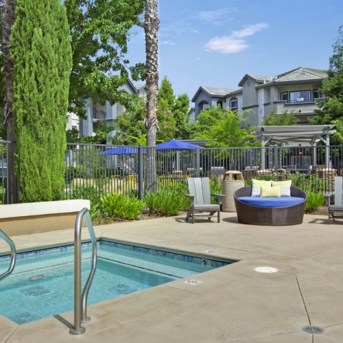 a swimming pool with chairs and trees around it